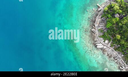 Ruhiges farbenprächtiges türkisblaues Meer in der Nähe der winzigen tropischen Vulkaninsel Koh Tao, einzigartiges kleines Paradies Nang Yuan. Drohne Blick auf friedliches Wasser in der Nähe von steinigen Stockfoto