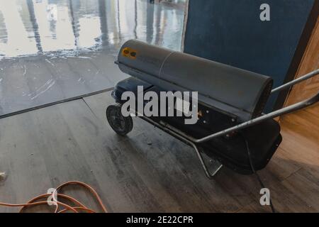 Die Heißluftpistole ist an das elektrische Netz und angeschlossen Erwärmt die Luft im Raum Stockfoto