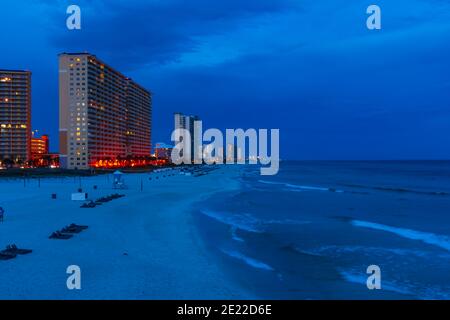 Die blaue Stunde kommt am Strand an, zufällige Hotels und Eigentumswohnungen beginnen zum Leben zu springen, wenn ihr Licht aufgeht Stockfoto