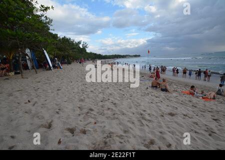 Bali, Indonesien - 12. Januar 2021: Einheimische und Touristen versammeln sich am Strand von Kuta zum Spaß, genießen Surfen und fotografieren die balinesische Kultur Stockfoto