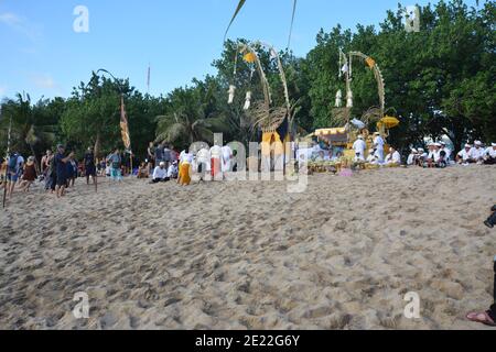 Bali, Indonesien - 12. Januar 2021: Einheimische und Touristen versammeln sich am Strand von Kuta zum Spaß, genießen Surfen und fotografieren die balinesische Kultur Stockfoto