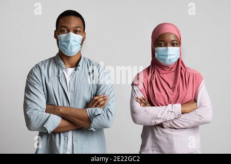Ernst muslim schwarzes Paar mit Gesichtsmasken auf Stockfoto