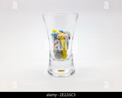 Stockholm, Schweden - 11. Januar 2021: Ein Cocktail aus Pillen in einem Schnapsglas. Verschiedene Pillen in vielen Farben. Könnte verwenden, um sucht oder Übervorstellung zu symbolisieren Stockfoto
