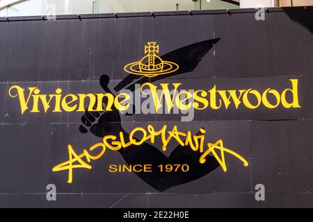 Nahaufnahme des Logos über dem Geschäft des Vivienne Westwood Anglomania-Logos auf seinem Flagship-Store in Harujuku. Tokio. Gelbe Buchstaben auf Schwarz. Stockfoto