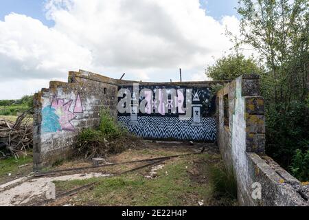 Verlassene verlassene Gebäude in einem Schaffeld, das ehemalige Richborough World war One Gefängnis, Haftanstalt. Seltsame fremde moderne Graffiti an der Wand. Stockfoto