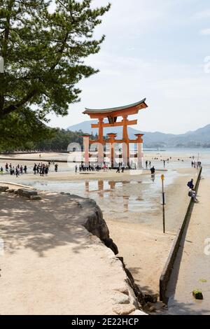 Touristen am Strand am Itsukushima (Miyajima) torii Tor, Japan Stockfoto