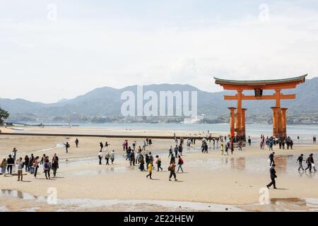 Touristen am Strand am Itsukushima (Miyajima) torii Tor, Japan Stockfoto