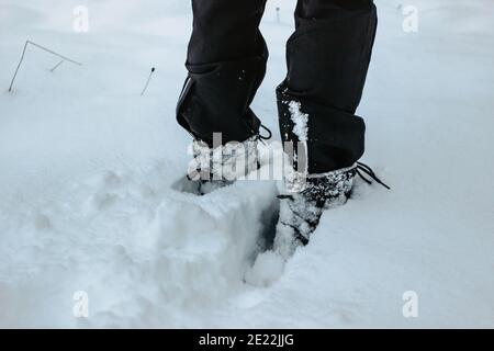 Detail der warmen wasserdichten Stiefel in tiefem Neuschnee.Weibliche Füße in schwarzen Schuhen, Winterwandern im Schnee.Low Winkel Ansicht der stehenden weiblichen Beine mit Schnee Stockfoto