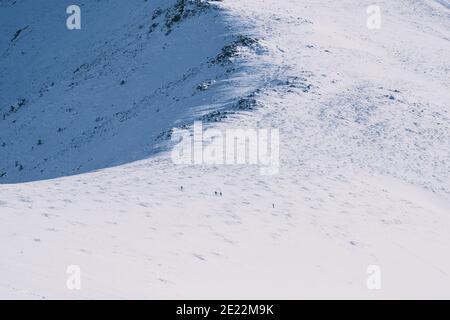 Kleine unerkennbare Gruppe von Backcountry-Skifahrern, die den Berg hinauffahren, Sierra de Guadarrama, Madrid Stockfoto