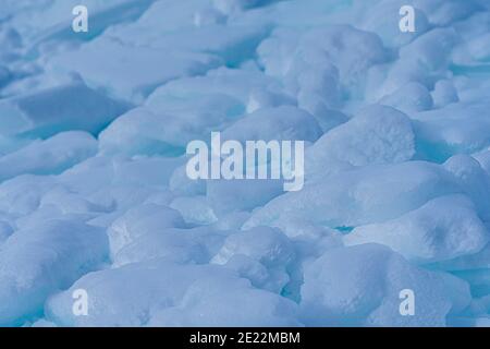 Makrotextur aus Eis und Schnee in Nahaufnahme. Blick im Freien auf Eisblöcke und Schnee im Winter. Fotos in hoher Qualität. Stockfoto