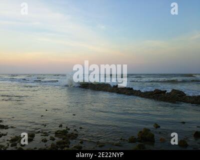 Blick auf starke Wellen stürzt über den Strand auf ein Klarer Himmel-Hintergrund Stockfoto