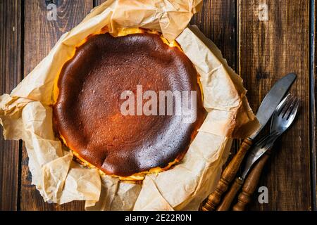 Draufsicht auf leckeren baskischen gebrannten Käsekuchen auf rustikalem Tisch Stockfoto