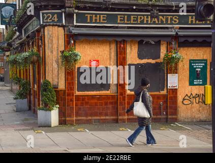 Eine Frau geht während der Coronavirus-Sperre in England am geschlossenen Elephant's Head Pub in Camden, London, vorbei. Stockfoto