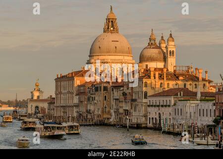 Sonnenuntergang Canal Grande - Abendsonne scheint auf Kuppeln der Basilika Santa Maria della Salute, am südlichen Eingang des Canal Grande, Venedig, Italien. Stockfoto