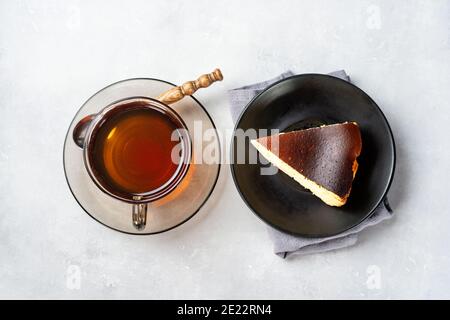 Ein Stück baskischen verbrannten Käsekuchen mit Tasse schwarz Tee Stockfoto
