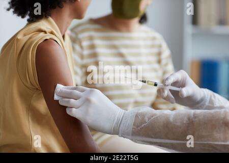 Nahaufnahme eines nicht erkennbaren männlichen Krankenpflegers, der in der Klinik ein afroamerikanisches Kind gegen Covid impft, Kopierraum Stockfoto