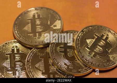 Gold glänzende wertvolle Bitcoins liegen übereinander Mit goldenem Hintergrund Stockfoto
