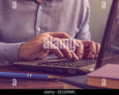 Blogger schreibt Text in einem Laptop. Der Mann tippt auf der Tastatur. Stockfoto