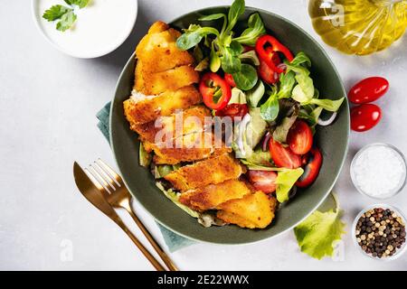 Draufsicht auf einen Teller mit köstlichen panierten Kabeljau mit Gesunder Salat Stockfoto