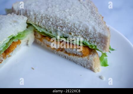 Norwich, Norfolk, Großbritannien - November 21 2020. Ein illustratives redaktionelles Foto einer Nahaufnahme eines Fischfinger- und Salatsandwiches auf Weißbrot Stockfoto