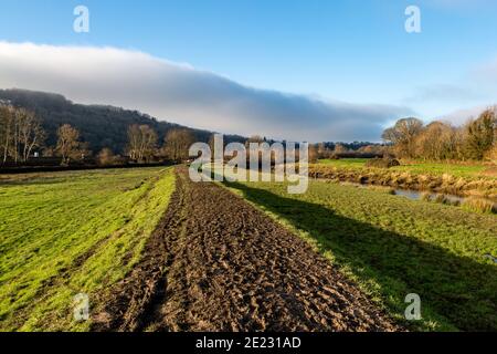 Ein schlammiger Pfad entlang des Flusses Ouse bei Lewes, an einem sonnigen Wintertag Stockfoto