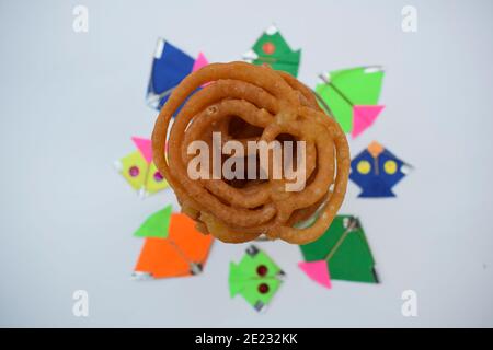 Beliebte süße Gericht Jalebi während indischen Kite-Festival von Uttarayan oder makar sankranti in gujarat gebraten. Dekoriert mit bunten Drachen. Sw Stockfoto