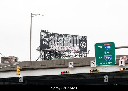 New York, NY - 11. Januar 2021: Regierungsfeindliche Graffiti auf der Plakatwand über der Autobahn in Queens Stockfoto