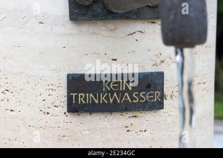 Kleines Metallwarnschild bei einem Brunnen mit dem Deutschen Text „kein Trinkwasser“, der in „kein Trinkwasser“ übersetzt wird Englische Sprache Stockfoto