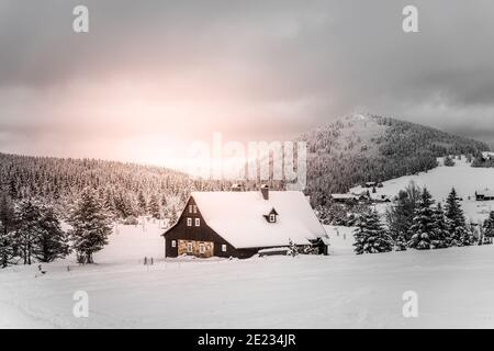Winter im Isergebirge. Wolkenverhangener Abend im Dorf Jizerka, Tschechische Republik Stockfoto
