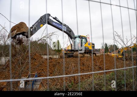 Beaconsfield, Buckinghamshire, Großbritannien. Januar 2021. Die Bauarbeiten an der A40 in Beaconsfield für ein neues medizinisches Zentrum und eine Apotheke haben begonnen. Es gibt Forderungen nach Beendigung der Bauarbeiten während der letzten Covid-19-Sperre, da Bauarbeiter oft von außerhalb des Gebiets reisen und es Bedenken gibt, dass sie Gefahr laufen könnten, Covid-19 an lokale Gemeinden zu übertragen, wenn sie lokale Geschäfte usw. nutzen.Quelle: Maureen McLean/Alamy Live News Stockfoto