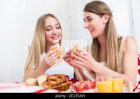 Mutter und Tochter beim Frühstück im Bett Stockfoto