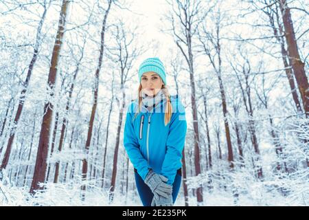 Frau trägt funktionelle Kleidung im Schnee Aufwärmen für den Sport Stockfoto
