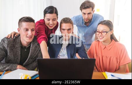 Frau zeigt ihren anderen Freunden auf Laptop Stockfoto