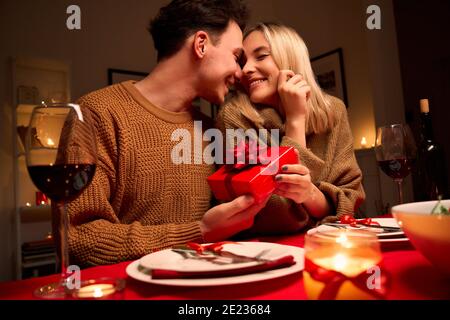 Liebevoller Mann geben rote Geschenkbox Umarmung geliebte Frau oder Valentinstag. Stockfoto