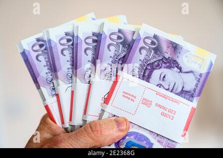 Nahaufnahme der Hand, die £5000 Bargeld in £20-Banknoten hält. Britische Währung. Britisches Pfund Sterling. Stockfoto