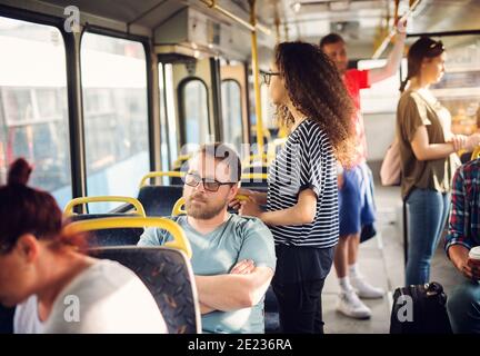 Nervous Mann sitzt in einem Bus und wartet auf sein Ziel zu bekommen. Stockfoto