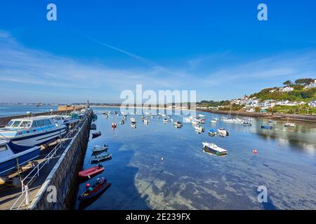 Bild von Grouville Bay im Hintergrund mit einem Teil von Gorey Harbour und Gorey Pier im Vordergrund auf einem sonnigen Erarl Mornong bei Flut. Gorey, Je Stockfoto