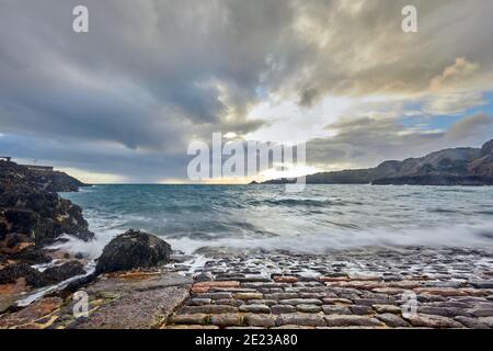 Bild von Bouley Bay am Fuße des Kopfsteinpflasterrutschens bei Ebbe mit einer langsamen Verschlusszeit, Vorgewende bei Sonnenaufgang. Jersey Channel Islands Stockfoto