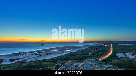 Bild von St Ouens Bay am Abend bei Sonnenuntergang mit Auto Licht Wanderwege mit rocco-Turm und Sanddünen. Jersey, Kanalinseln, großbritannien Stockfoto