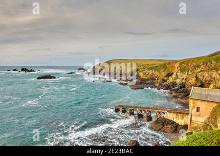 Bild der Bucht und ehemaligen Life-Bootstation in Lizard Point, Cornwall, mit einem bewölkten Himmel. Stockfoto