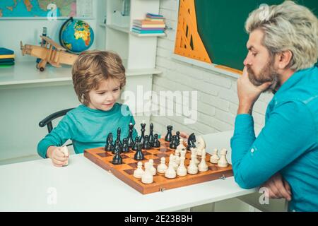 Vatertag. Konzentrierter Junge, der Schachstrategie entwickelt. Cleveres konzentriertes und denkendes Kind beim Schachspielen Stockfoto