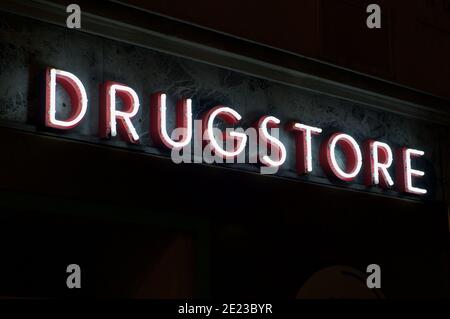 Leuchtende Drogerieaufschrift in Neon, die an einem Gebäude einer Apotheke in Lugano, Schweiz, hängt Stockfoto