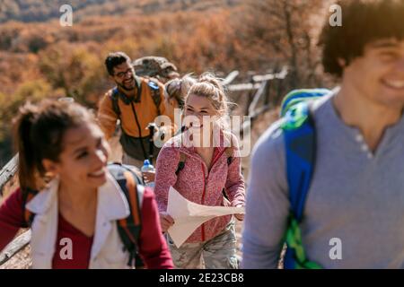 Wanderer, die den Hügel erklimmen. Sie gehen in der Reihe. Im Hintergrund Wald. Herbstsaison, Erlebniskonzept. Stockfoto
