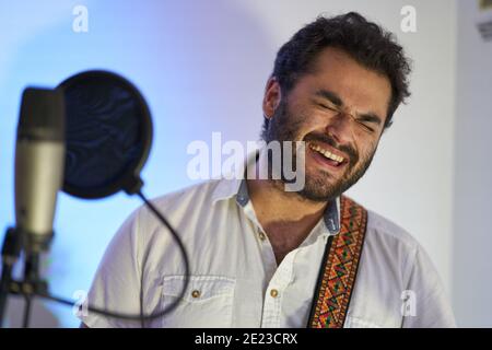 Professioneller männlicher Musiker mit E-Gitarre singen begeistert und Aufnahme In einem Studio Stockfoto