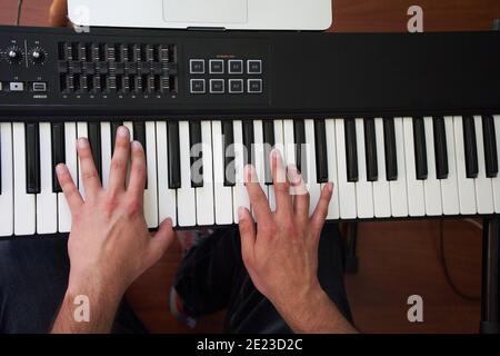 Nahaufnahme Draufsicht der männlichen Musikerhände, die auf elektronischer Musik spielen Klaviertastatur im Studio Stockfoto