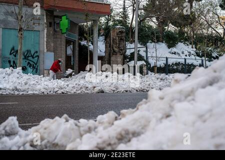 Ein Mann entfernt Schnee und Eis aus dem Portal seines Gebäudes in Madrid.nach heftigem Schneefall in Spanien stürzt Madrid, die spanische Hauptstadt, in Chaos wegen des Eises, das durch niedrige Temperaturen verursacht wird. Der Schneesturm Filomena weicht einem Antizyklon, der minimale Temperaturen von bis zu -15ºC verursachen wird, und Frost der ernsten Gefahr. Nach Angaben der staatlichen Meteorologischen Agentur (AEMET für seine Abkürzung in Spanisch) sind dies historische Temperaturen in Madrid. Stockfoto