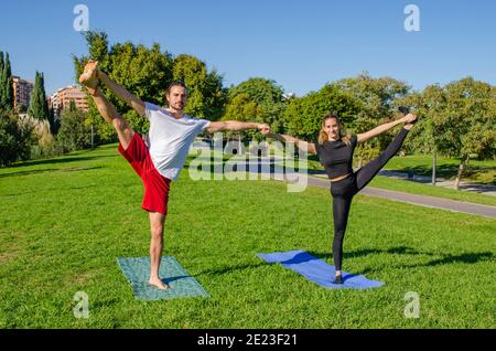 Junge sportliche Paar macht Yoga am Tag Stockfoto