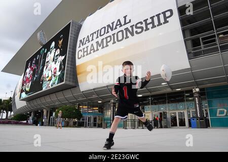 Miami, Usa. Januar 2021. Cooper Stuckey, 7, aus Springfield, Ohio, spielt mit einem Fußball außerhalb des Hard Rock Stadium vor dem 2021 NCAA National Championship Fußballspiel zwischen Alabama und Ohio State in Miami am Montag, 11. Januar 2021. Foto von Hans Deryk/UPI Credit: UPI/Alamy Live News Stockfoto