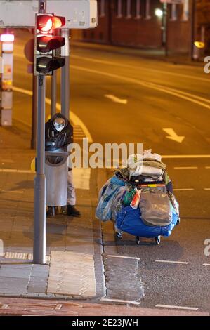 Köln, Deutschland. Januar 2021. Ein Mann sucht in einem Mülleimer in der Innenstadt nach Mehrwegflaschen. Besonders für Obdachlose ist die Absperrung eine harte Zeit. Aufgrund des Mangels an Touristen und Einkäufern, gibt es auch ein Mangel an Einkommen aus dem Sammeln von Flaschen oder den Verkauf von Zeitungen. Quelle: Henning Kaiser/dpa/Alamy Live News Stockfoto