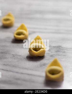 Linie von Tortellini auf Marmor Stockfoto